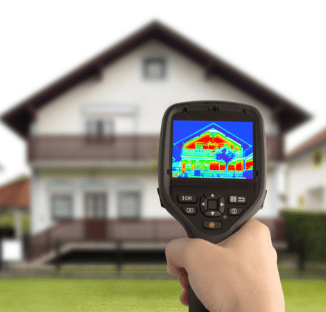 A person holding up a thermal camera to check the house